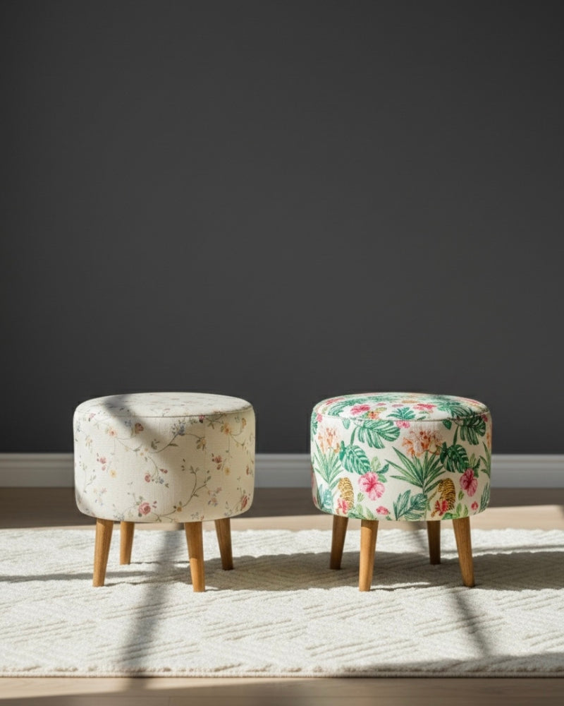 Two floral-patterned stools on a light wooden floor with a dark gray wall background.